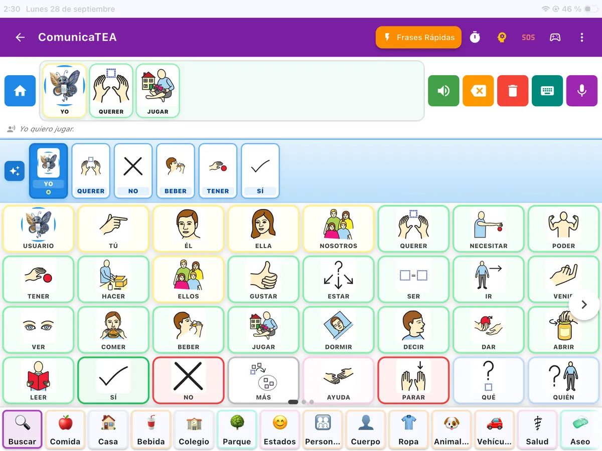 El comunicador de ComunicaTEA en una tablet. En la barra de la frase están los pictogramas «yo», «querer» y «jugar», y debajo se lee «Yo quiero jugar.». Bajo la barra hay una fila de palabras sugeridas, el vocabulario núcleo en una rejilla de pictogramas y, abajo, las carpetas temáticas: Comida, Casa, Bebida, Colegio, Parque y otras.